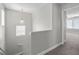 Hallway leading upstairs, featuring a pendant light, neutral colors and carpet flooring at 9625 Gatesville Ave, Las Vegas, NV 89148