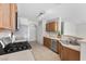 Kitchen view features stainless appliances, wooden cabinets, breakfast bar, and tile flooring at 9625 Gatesville Ave, Las Vegas, NV 89148