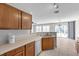 Bright kitchen with wood cabinets, light countertops, and view into living area with ceiling fan and sliding glass doors at 9625 Gatesville Ave, Las Vegas, NV 89148