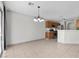 Open living room and kitchen with tile flooring, neutral paint, and large windows at 9625 Gatesville Ave, Las Vegas, NV 89148