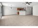 Open living room with tile flooring, ceiling fan, and bar top kitchen counter at 9625 Gatesville Ave, Las Vegas, NV 89148