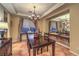 Traditional dining room with dark wood table and chairs, chandelier, and tile floors at 9733 Plateau Heights Pl, Las Vegas, NV 89144