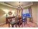Inviting dining room with dark wood table, tile flooring, and decorative light fixture at 9733 Plateau Heights Pl, Las Vegas, NV 89144