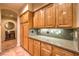 Kitchen featuring granite countertops, tile backsplash, and abundant storage in wooden cabinetry at 9733 Plateau Heights Pl, Las Vegas, NV 89144