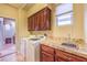 Functional laundry room with wooden cabinets, tiled countertop, washer, and dryer at 9733 Plateau Heights Pl, Las Vegas, NV 89144