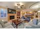 Open-concept living room with fireplace, ceiling fan, and kitchen access at 9733 Plateau Heights Pl, Las Vegas, NV 89144