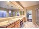 Primary bathroom featuring dual sinks, walk-in closets, and a glass-enclosed shower at 9733 Plateau Heights Pl, Las Vegas, NV 89144