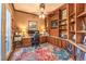 Well-appointed office with built-in bookshelves, desk, and a colorful rug at 9733 Plateau Heights Pl, Las Vegas, NV 89144