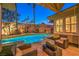 Inviting pool area with well-manicured landscaping, comfortable seating and palm trees at 9733 Plateau Heights Pl, Las Vegas, NV 89144