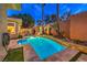 Backyard view of the beautiful pool with turf and manicured landscaping at 9733 Plateau Heights Pl, Las Vegas, NV 89144