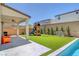 Inviting backyard with a covered patio, pool, artificial grass, and play structure perfect for outdoor enjoyment at 10161 Bismarck Palms Ave, Las Vegas, NV 89166