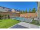 Backyard showcases artificial turf, a fenced pool, and tasteful landscaping for a serene outdoor experience at 10161 Bismarck Palms Ave, Las Vegas, NV 89166