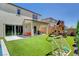 Expansive backyard features artificial grass, a play structure, covered patio, and easy access from the living area at 10161 Bismarck Palms Ave, Las Vegas, NV 89166