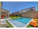 Spacious backyard with a pool, artificial turf, covered patio, and a play structure, ideal for Gathering fun at 10161 Bismarck Palms Ave, Las Vegas, NV 89166