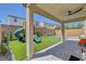 Inviting backyard with a covered patio, artificial turf, playground, and pool at 10161 Bismarck Palms Ave, Las Vegas, NV 89166
