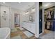Well-lit bathroom with a double vanity, soaking tub, shower, and a large walk-in closet at 10161 Bismarck Palms Ave, Las Vegas, NV 89166