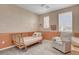 Cozy bedroom with whimsical wallpaper, natural light, and a comfortable sitting area at 10161 Bismarck Palms Ave, Las Vegas, NV 89166