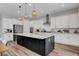 Bright kitchen features white cabinets, stainless steel appliances, and a contrasting island with elegant pendant lighting at 10161 Bismarck Palms Ave, Las Vegas, NV 89166