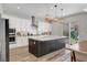 Bright kitchen showcases white cabinets, a stainless steel refrigerator, and a large island with backyard view at 10161 Bismarck Palms Ave, Las Vegas, NV 89166