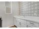 This laundry room has a stylish wallpaper and white countertops at 10161 Bismarck Palms Ave, Las Vegas, NV 89166