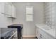 Modern laundry room with stainless steel washer and dryer, sink, and stylish wallpaper at 10161 Bismarck Palms Ave, Las Vegas, NV 89166