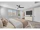 Tranquil main bedroom with a large bed, ceiling fan, and view of the community outside at 10161 Bismarck Palms Ave, Las Vegas, NV 89166