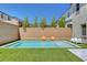 Beautiful backyard showcases a modern pool with seating area, surrounded by lush artificial grass and privacy walls at 10161 Bismarck Palms Ave, Las Vegas, NV 89166