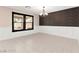 Dining room with tile floors, white wainscoting, black trimmed windows and modern chandelier at 11755 Garland Grove Ln, Las Vegas, NV 89183