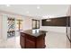 Open-concept living space with kitchen island and access to the patio through sliding glass doors at 11755 Garland Grove Ln, Las Vegas, NV 89183