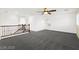 Spacious loft with neutral walls and plush carpet, with a decorative railing overlooking the stairs at 11755 Garland Grove Ln, Las Vegas, NV 89183