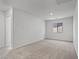 A bright bedroom with neutral carpet, white walls, and natural light from a window at 1701 Desert Path Ave, North Las Vegas, NV 89032