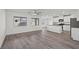 Open-concept living space with wood-look floors connecting to the kitchen at 1701 Desert Path Ave, North Las Vegas, NV 89032