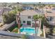 Beautiful backyard pool with putting green, palm trees, covered patio, and a white stucco home at 1811 Country Meadows Dr, Henderson, NV 89012
