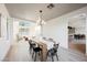 Elegant dining room with modern lighting, seating for six, and bright windows at 1811 Country Meadows Dr, Henderson, NV 89012