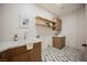 Well-lit laundry room with checkered floors, open shelving, and built-in cabinets at 1811 Country Meadows Dr, Henderson, NV 89012
