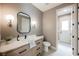 A powder room with white marble vanity and a black framed mirror with modern sconce lighting at 1811 Country Meadows Dr, Henderson, NV 89012