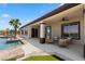 Relax on this covered patio with plush seating and views of the pool and lush landscaping at 1950 Colvin Run Dr, Henderson, NV 89052