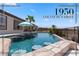 An inviting backyard pool features a swim-up bar, cool blue water, and patio umbrella for relaxing shade at 1950 Colvin Run Dr, Henderson, NV 89052
