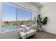Scenic view from a bright room with a comfortable bench overlooking a pool and lush landscape, perfect for relaxation at 1950 Colvin Run Dr, Henderson, NV 89052