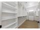 Bright walk-in closet features white shelving and drawers with wood flooring and plenty of storage space at 1950 Colvin Run Dr, Henderson, NV 89052