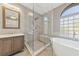 Modern bathroom featuring a walk-in shower with glass enclosure and a soaking tub near a glass block window at 1999 Oliver Springs St, Henderson, NV 89052