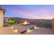 Relaxing outdoor area with fire pit, pavers, manicured lawn, beautiful mountain and city views at 2069 Alto Vista Dr, Henderson, NV 89052