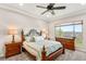 A bedroom with a ceiling fan, carpet, and two dressers; a window looks out onto the landscape at 2069 Alto Vista Dr, Henderson, NV 89052