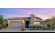 Charming single-story home featuring manicured landscaping and a neutral color palette at sunset at 2069 Alto Vista Dr, Henderson, NV 89052