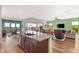 Spacious kitchen with stainless steel appliances, an island with seating, and an adjacent living space with a view at 2069 Alto Vista Dr, Henderson, NV 89052