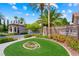 Elegant entrance to Country Rose Estates featuring lush landscaping, a guard house, and stone signage at 2113 Scarlet Rose Dr, Las Vegas, NV 89134