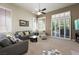 Bright living room featuring carpet floors, plantation shutters, and comfortable seating at 2113 Scarlet Rose Dr, Las Vegas, NV 89134