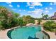 Inviting backyard pool with a small waterfall and lush landscaping creating a private oasis at 2113 Scarlet Rose Dr, Las Vegas, NV 89134