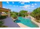 Beautiful backyard pool with rock waterfall feature surrounded by lush greenery and a concrete patio at 2113 Scarlet Rose Dr, Las Vegas, NV 89134