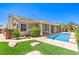 Inviting backyard with a sparkling pool, lush green lawn, and covered patio, perfect for outdoor relaxation at 2158 High Mesa Dr, Henderson, NV 89012